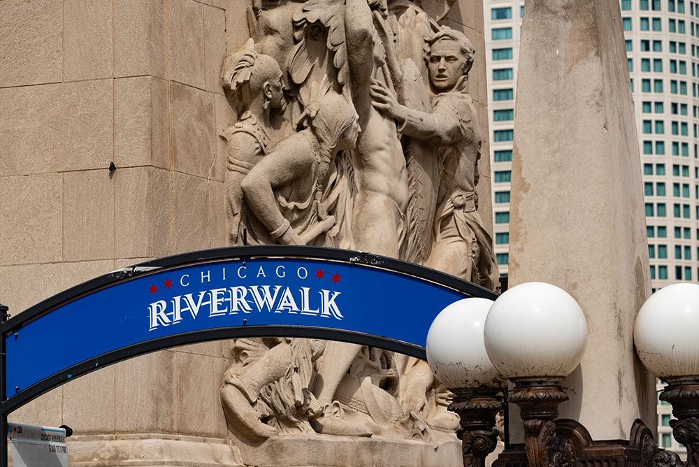 Riverwalk signage along the Chicago River in downtown Chicago with Michigan Avenue bas-relief